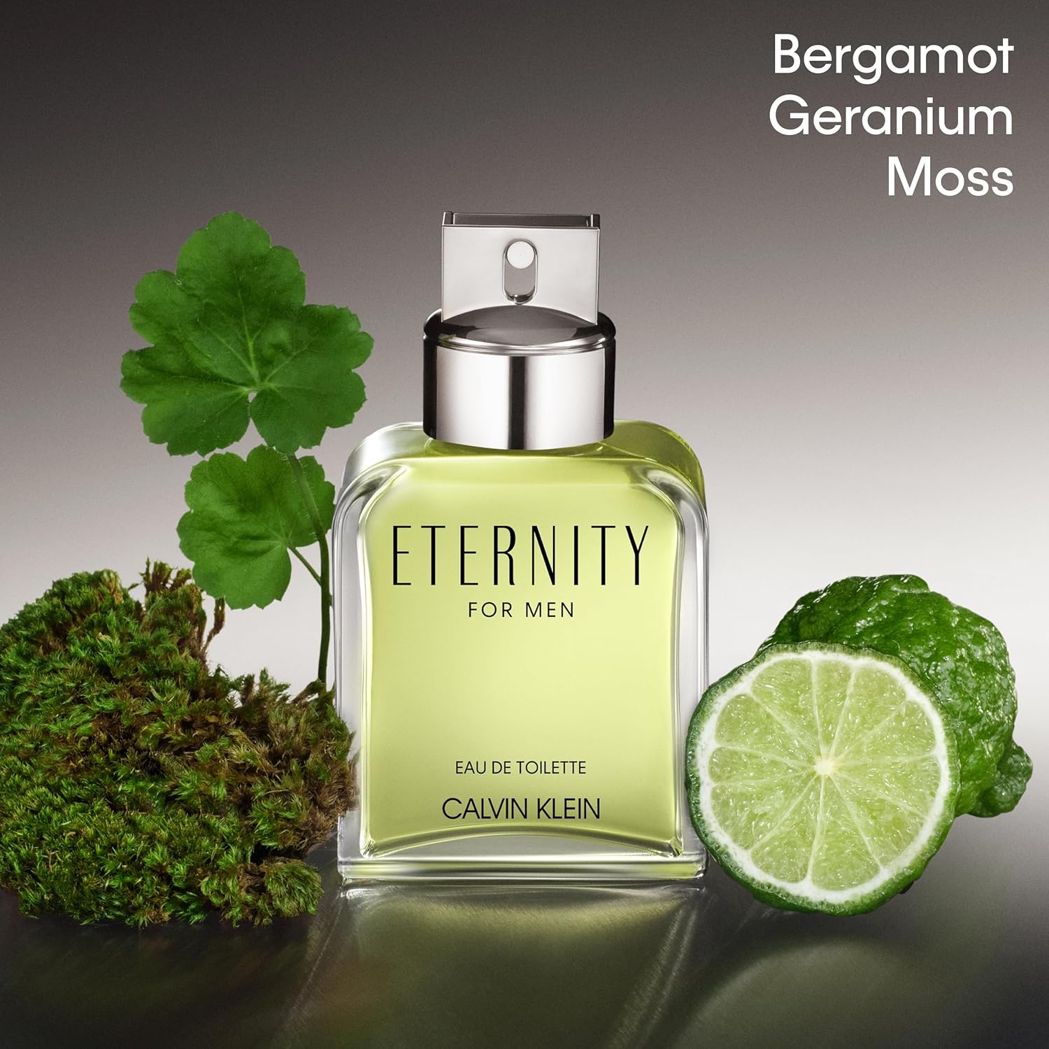 Calvin Klein Eternity for Men Bergamot Geranium Moss perfume bottle with green leaves and lime on a gray background
